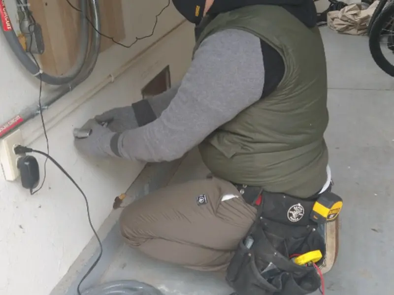 Electrician performing outlet wiring in a Bemiss garage